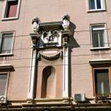 Sulla facciata che fronteggia l'antica Manifattura dei tabacchi, campeggia un�edicola celebrativa di chiara ascendenza michelangiolesca con inciso l�anno fascista di edificazione (1928). Tra le due colonne in marmo, ingrigite e sormontate dallo stemma sabaudo, regnano la scultura di un'aquila, antico simbolo romano ripreso dal regime in molte costruzioni, e una nicchia vuota che quasi sicuramente in origine ospitava un fascio littorio